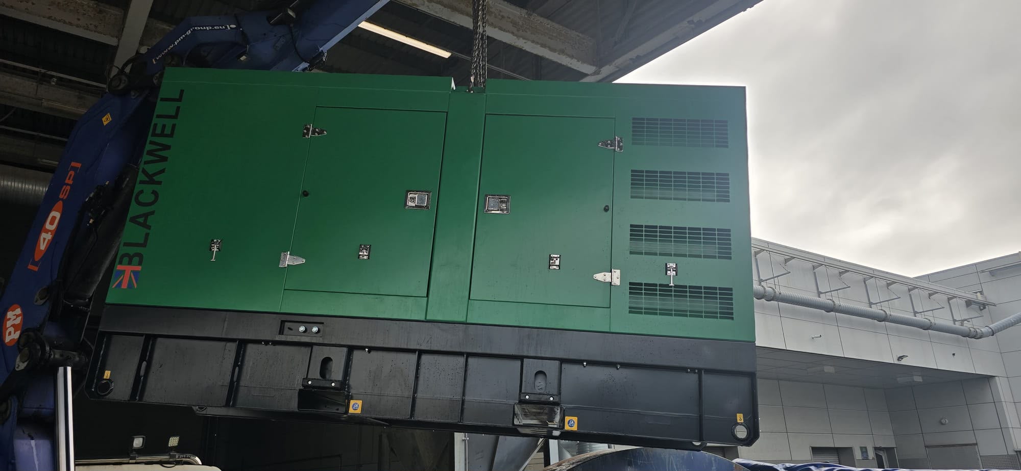 Green Blackwell standby generator being lifted by crane at the Merseyside printing facility